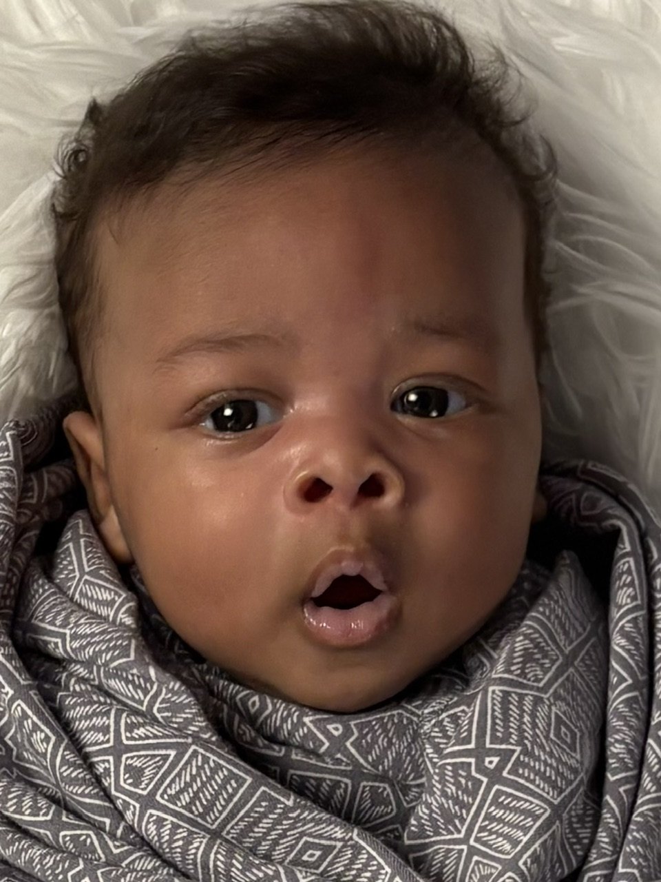 Baby portrait with open eyes and a rounded open mouth