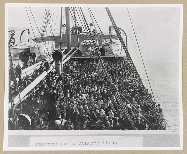 Black and white photograph of immigrants aboard a ship coming to America